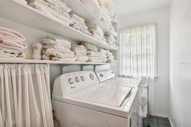 washroom with washing machine and dryer and dark tile patterned flooring