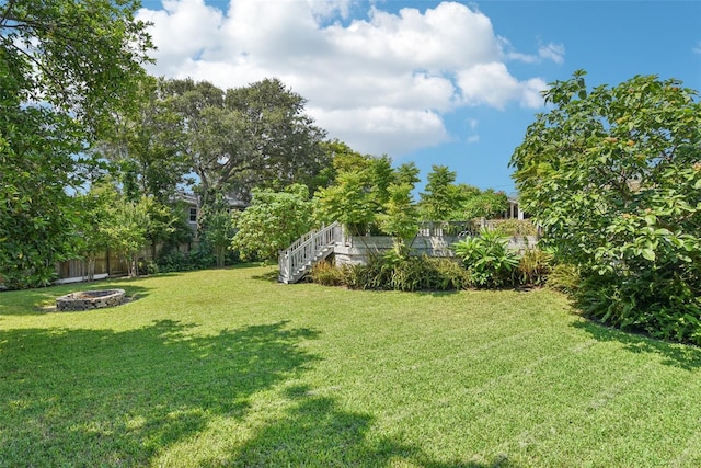 view of yard featuring a wooden deck and a fire pit