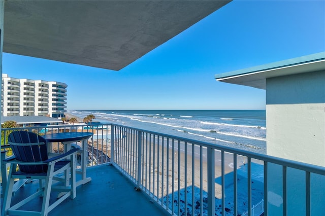 balcony featuring a water view and a beach view