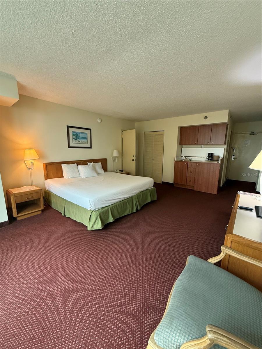 carpeted bedroom with a textured ceiling and a closet