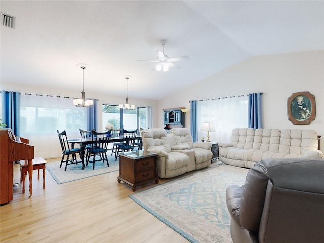 living room featuring ceiling fan with notable chandelier, vaulted ceiling, and light hardwood / wood-style floors