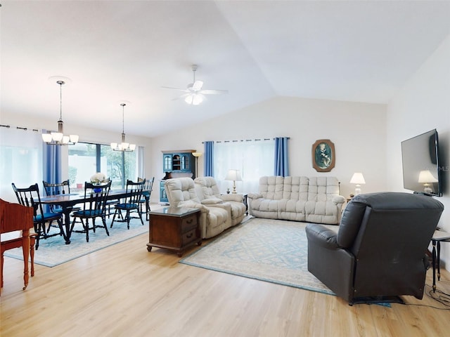 living room with ceiling fan with notable chandelier, vaulted ceiling, and light hardwood / wood-style floors