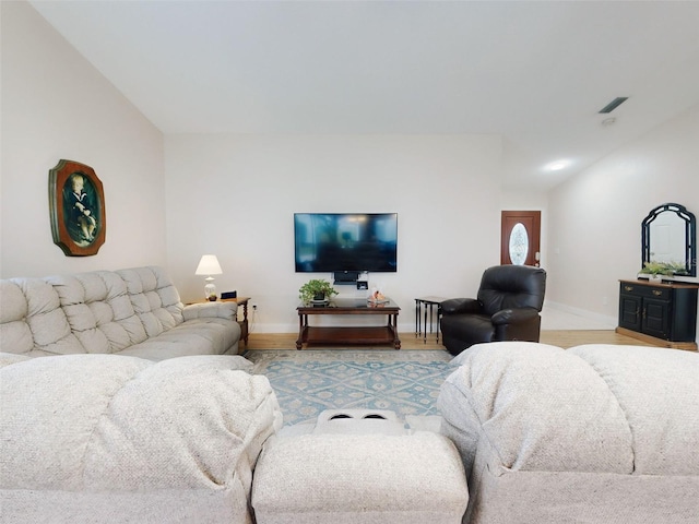 living room featuring lofted ceiling and light wood-type flooring