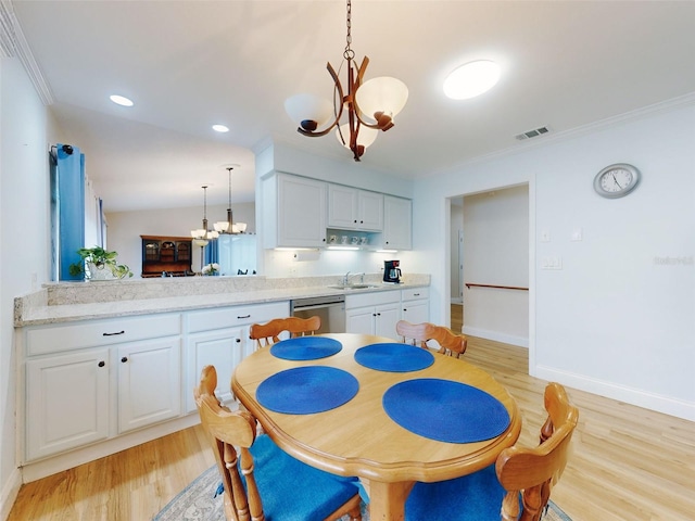 dining room with an inviting chandelier, sink, light hardwood / wood-style flooring, and ornamental molding