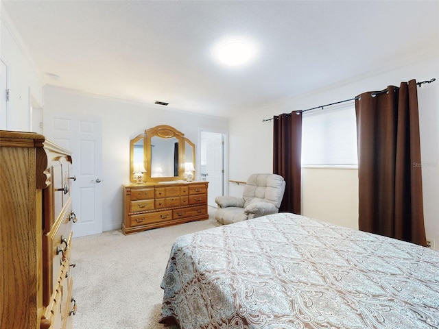 bedroom with ornamental molding and light carpet