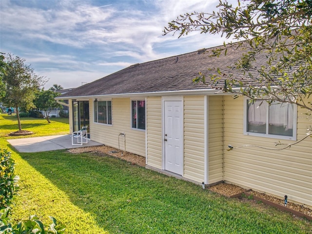 rear view of property featuring a patio area and a lawn