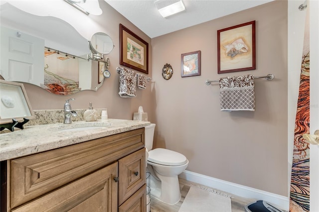 bathroom featuring vanity, a textured ceiling, and toilet