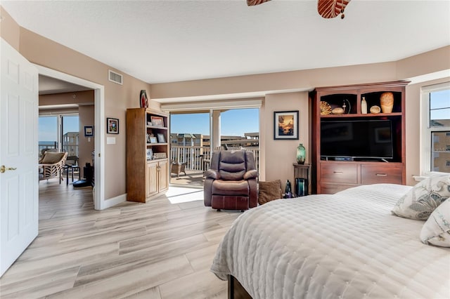 bedroom with light hardwood / wood-style floors, multiple windows, and access to outside