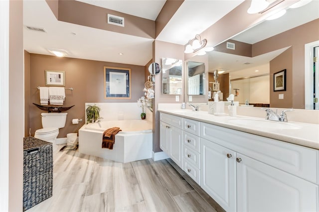 bathroom with hardwood / wood-style flooring, vanity, toilet, and tiled tub