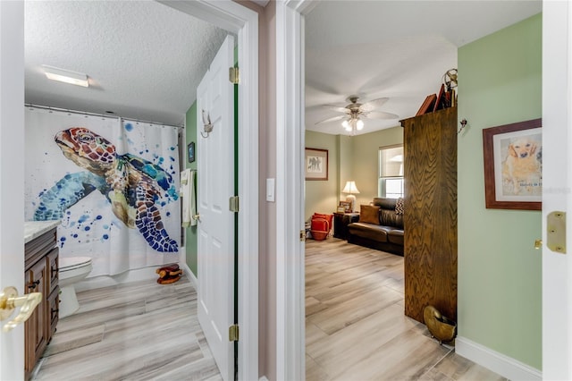 hallway featuring a textured ceiling and light wood-type flooring