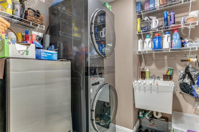 clothes washing area with stacked washing maching and dryer and sink