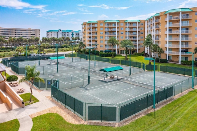 view of tennis court featuring a yard