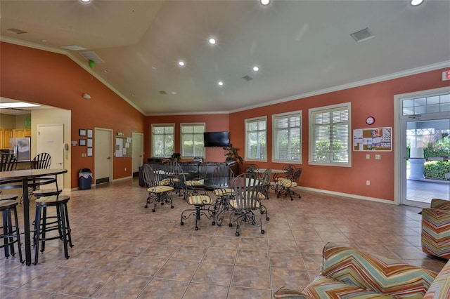 dining space with vaulted ceiling, ornamental molding, and light tile patterned flooring