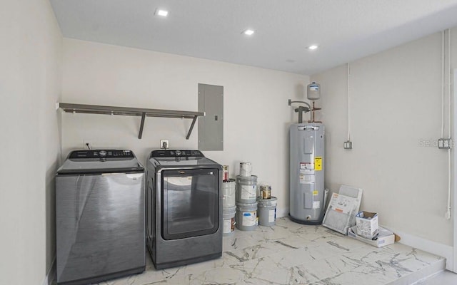 clothes washing area with electric panel, electric water heater, and washing machine and clothes dryer