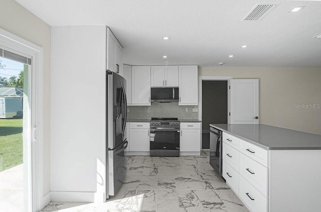 kitchen featuring tasteful backsplash, appliances with stainless steel finishes, and white cabinets