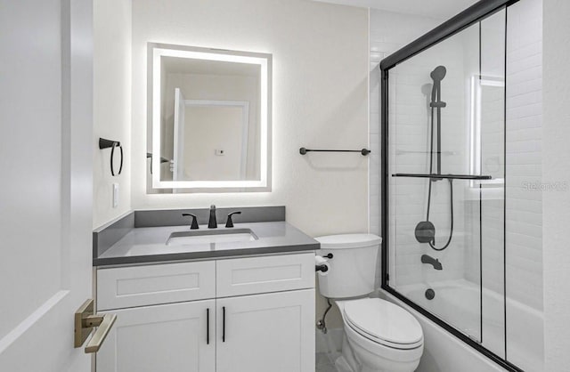 full bathroom featuring vanity, toilet, and combined bath / shower with glass door