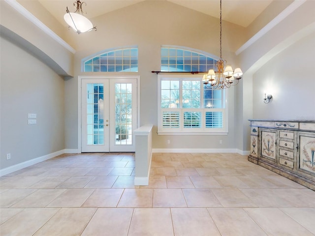 entrance foyer featuring french doors, an inviting chandelier, high vaulted ceiling, light tile patterned floors, and ornamental molding