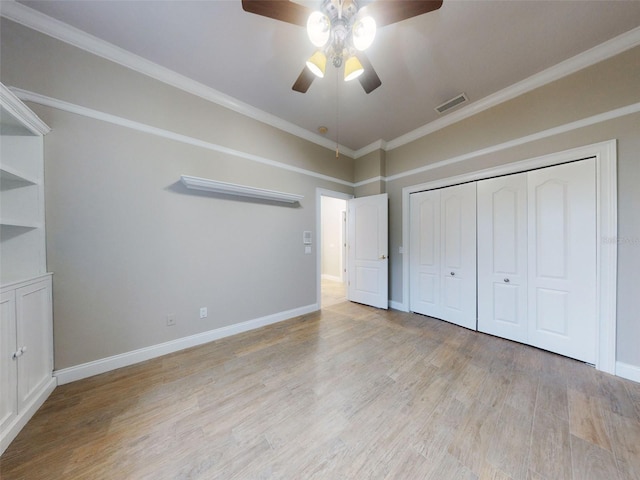 unfurnished bedroom featuring ceiling fan, ornamental molding, light hardwood / wood-style floors, and a closet