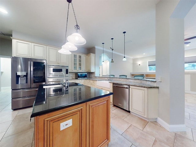 kitchen featuring pendant lighting, stainless steel appliances, an island with sink, light tile patterned flooring, and kitchen peninsula