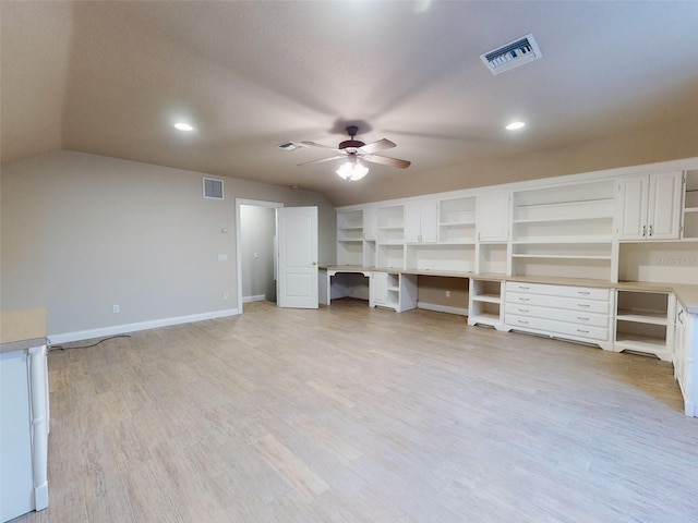 unfurnished living room with light hardwood / wood-style floors, ceiling fan, built in desk, and vaulted ceiling