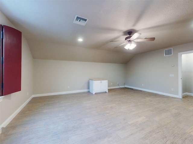 additional living space with vaulted ceiling, light hardwood / wood-style floors, and ceiling fan