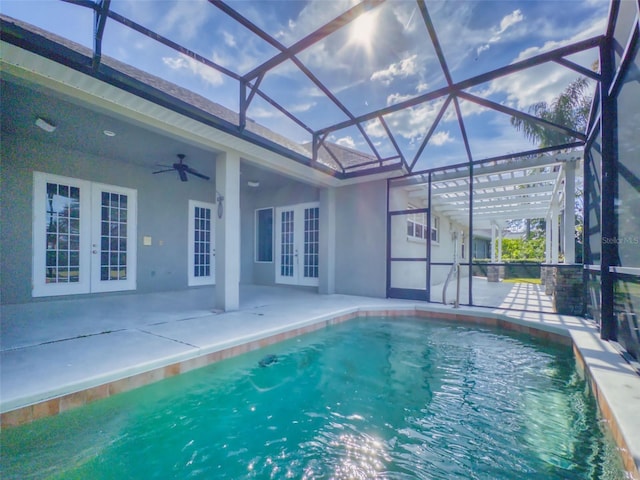 view of swimming pool with french doors, ceiling fan, a lanai, and a patio