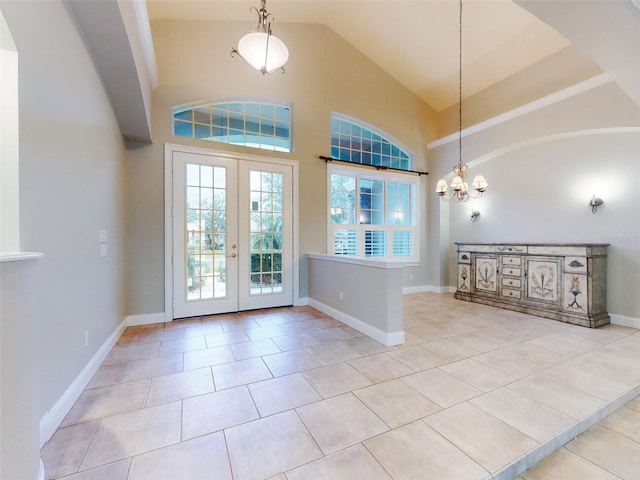 foyer with vaulted ceiling, french doors, a chandelier, and light tile patterned flooring