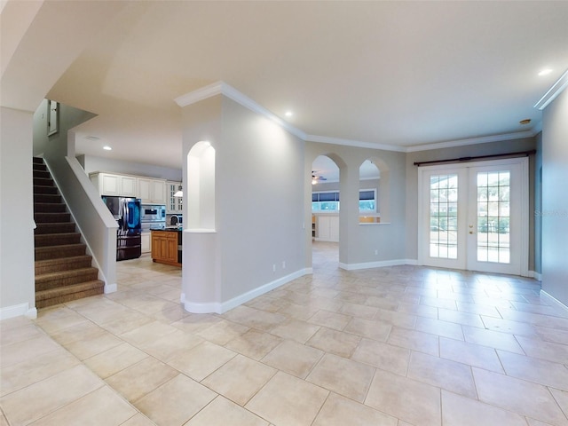 tiled empty room featuring french doors and ornamental molding