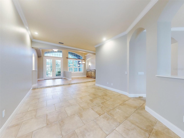 unfurnished living room with light tile patterned floors, ornamental molding, and french doors