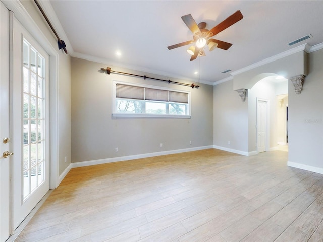 spare room with a wealth of natural light, ornamental molding, ceiling fan, and light wood-type flooring