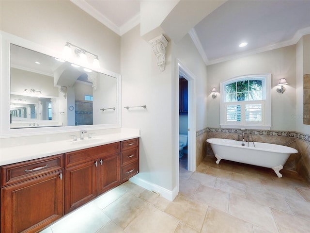 bathroom with tile walls, vanity, ornamental molding, a tub, and toilet