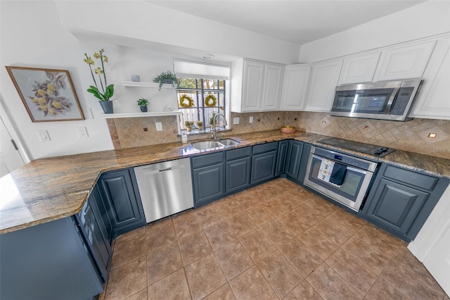 kitchen with white cabinetry, appliances with stainless steel finishes, blue cabinetry, tasteful backsplash, and sink