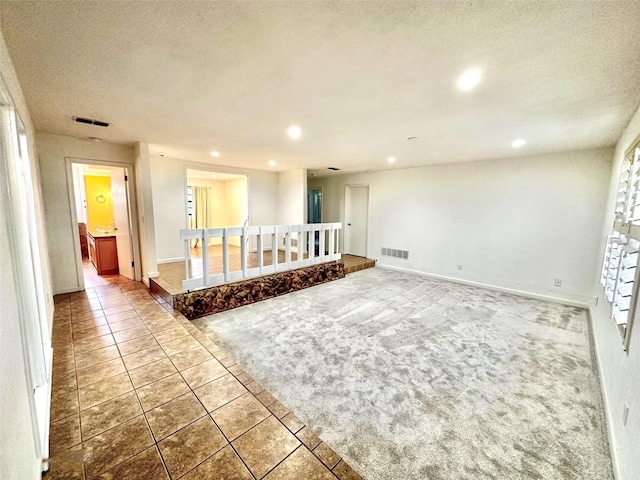 unfurnished room featuring a textured ceiling and tile patterned floors