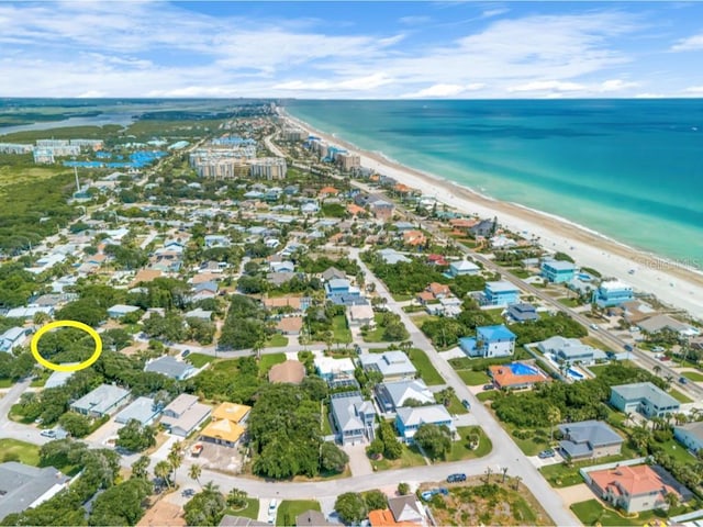 drone / aerial view with a water view and a beach view