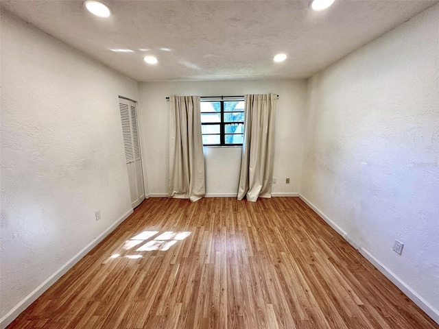 unfurnished room with wood-type flooring