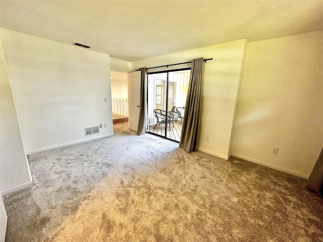 carpeted empty room with a textured ceiling