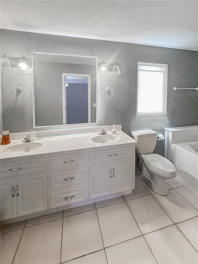 bathroom featuring tile patterned flooring, vanity, a bathing tub, and toilet