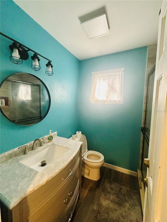 bathroom with vanity, wood-type flooring, and toilet