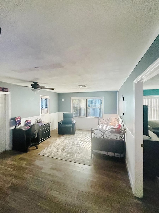 bedroom featuring hardwood / wood-style flooring, a textured ceiling, and ceiling fan