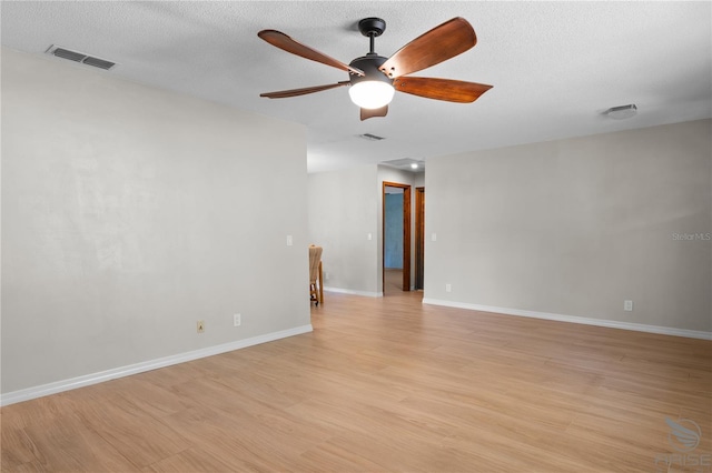 empty room featuring ceiling fan, a textured ceiling, and light wood-type flooring