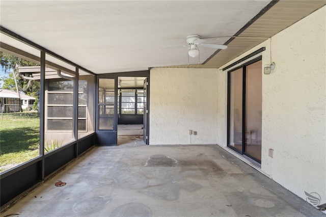 unfurnished sunroom with ceiling fan