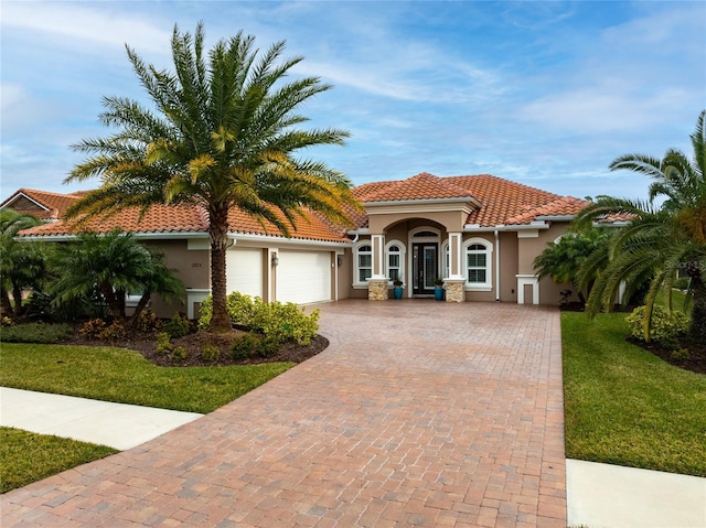 mediterranean / spanish-style house featuring a garage and a front yard