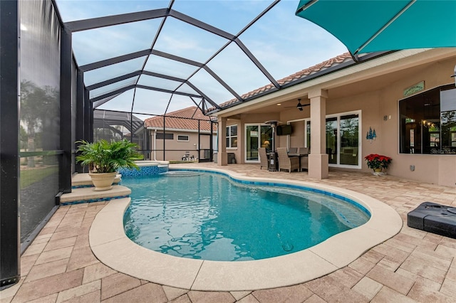 view of pool featuring glass enclosure, an in ground hot tub, a patio area, and ceiling fan