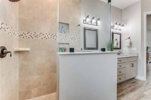 bathroom featuring hardwood / wood-style flooring, a shower, and vanity