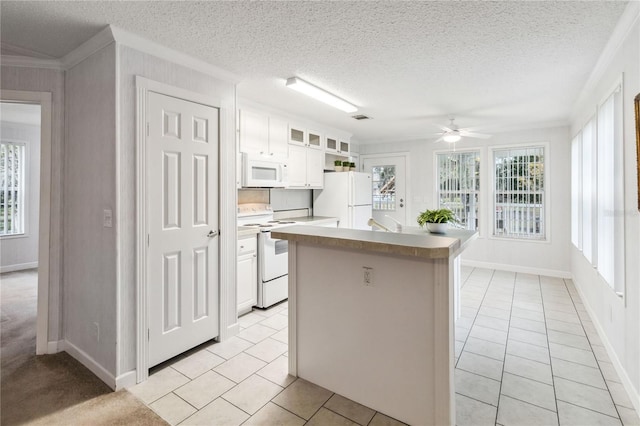 kitchen with white cabinetry, a center island, light tile patterned floors, and white appliances