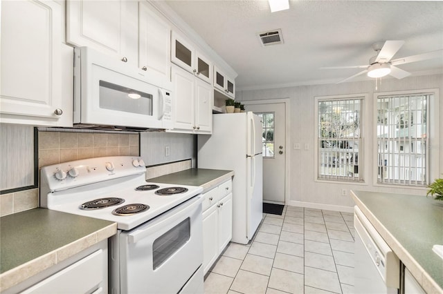 kitchen with tasteful backsplash, white cabinets, light tile patterned floors, ceiling fan, and white appliances