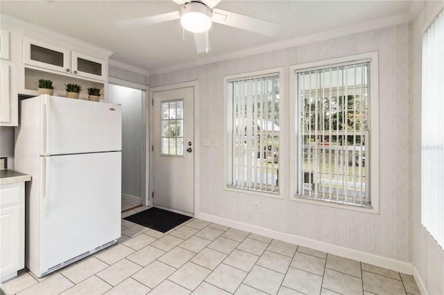 entryway with ceiling fan, ornamental molding, and light tile patterned floors