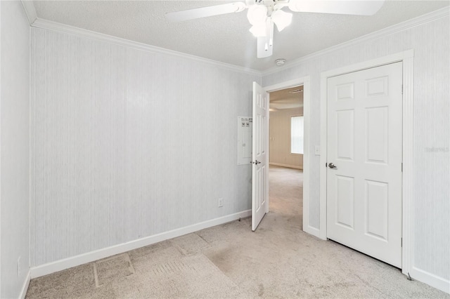 unfurnished room featuring ornamental molding, light colored carpet, ceiling fan, and a textured ceiling