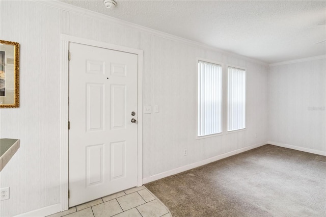 entryway featuring crown molding, a textured ceiling, baseboards, and light tile patterned floors