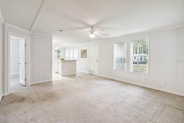 unfurnished living room featuring a ceiling fan, light carpet, ornamental molding, and visible vents